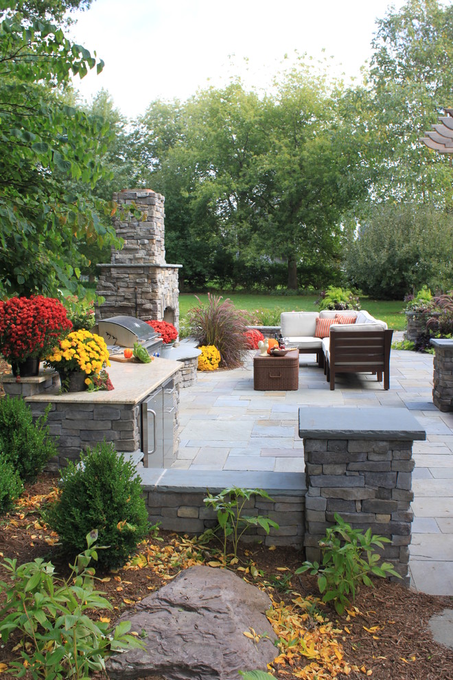 Inspiration for a mid-sized transitional full sun backyard stone landscaping in Chicago for spring.
