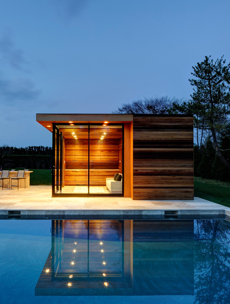 This is an example of a contemporary pool in New York with a pool house.