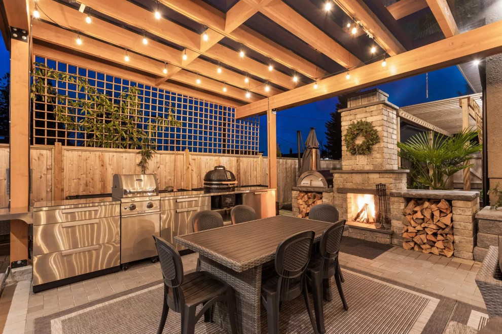 Photo of a large traditional back patio in Vancouver with an outdoor kitchen, brick paving and a pergola.
