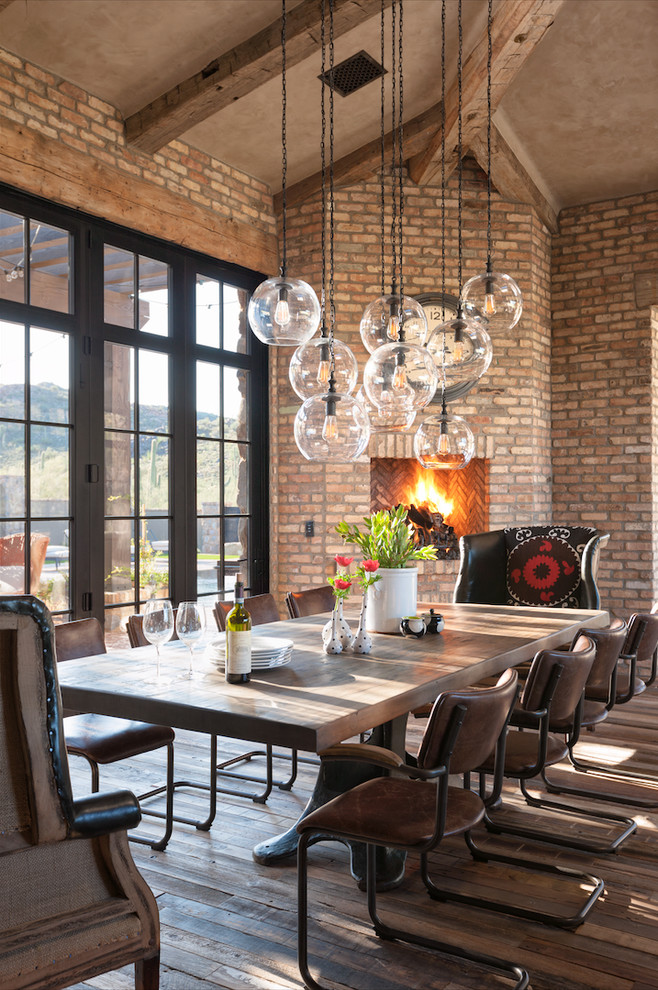 Example of a large farmhouse medium tone wood floor dining room design in Phoenix with a corner fireplace