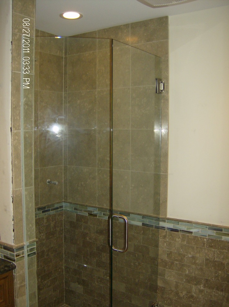 Photo of a small beach style 3/4 bathroom in Santa Barbara with an undermount sink, raised-panel cabinets, light wood cabinets, granite benchtops, a japanese tub, an alcove shower, a two-piece toilet, multi-coloured tile, stone tile, white walls and travertine floors.