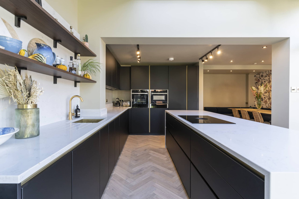 Idéer för ett litet skandinaviskt vit kök, med en undermonterad diskho, luckor med profilerade fronter, svarta skåp, bänkskiva i kvartsit, vitt stänkskydd, svarta vitvaror, en köksö och brunt golv