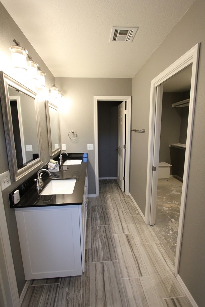 Inspiration for a mid-sized contemporary master bathroom in Other with shaker cabinets, white cabinets, an open shower, gray tile, porcelain tile, grey walls, ceramic floors, an undermount sink, granite benchtops, grey floor, an open shower and black benchtops.