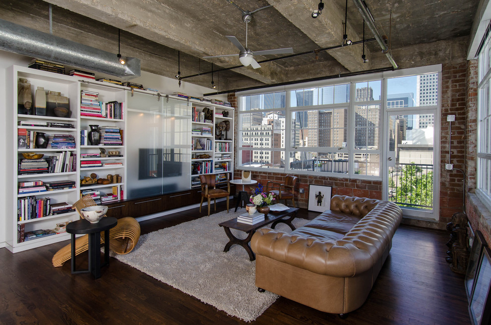 Inspiration for an industrial living room in Houston with a library and a concealed tv.