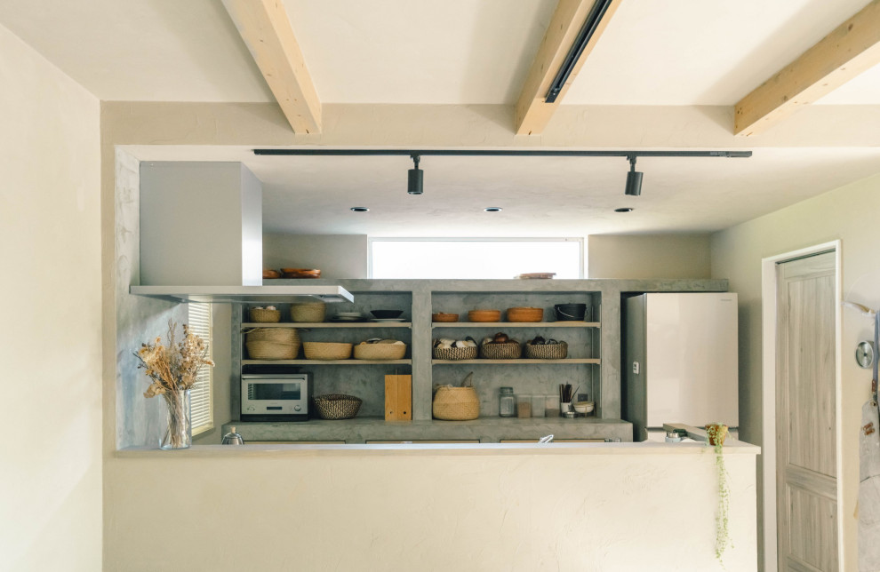 Cette photo montre une petite cuisine ouverte linéaire avec une crédence grise, une crédence en ardoise, un électroménager en acier inoxydable, sol en béton ciré, un sol gris et un plan de travail gris.