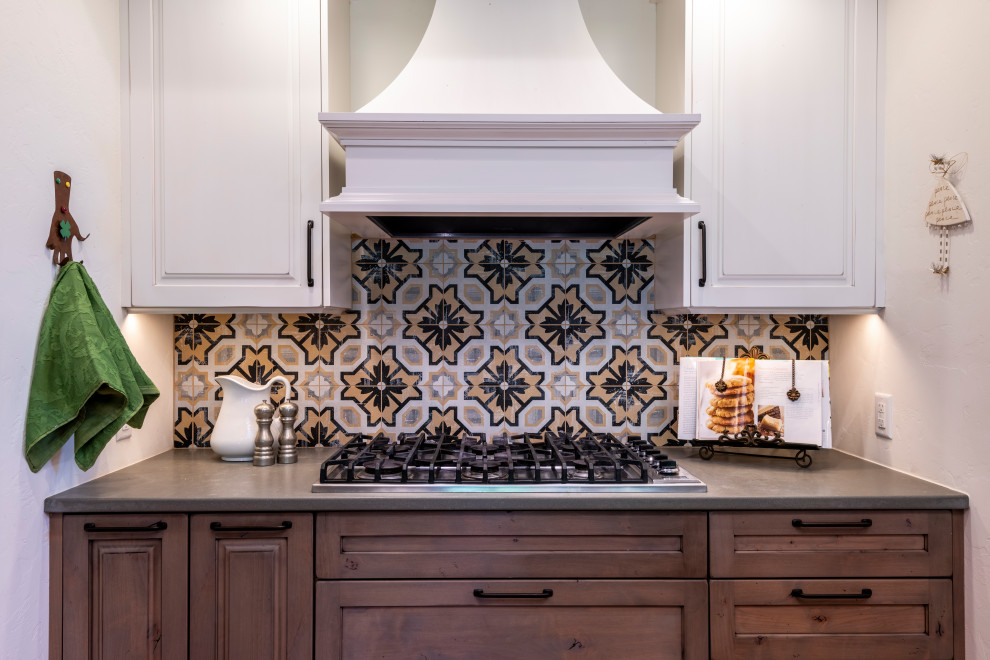 Design ideas for a mid-sized u-shaped kitchen in Other with a farmhouse sink, raised-panel cabinets, distressed cabinets, quartz benchtops, multi-coloured splashback, cement tile splashback, stainless steel appliances, terra-cotta floors, with island, orange floor and white benchtop.