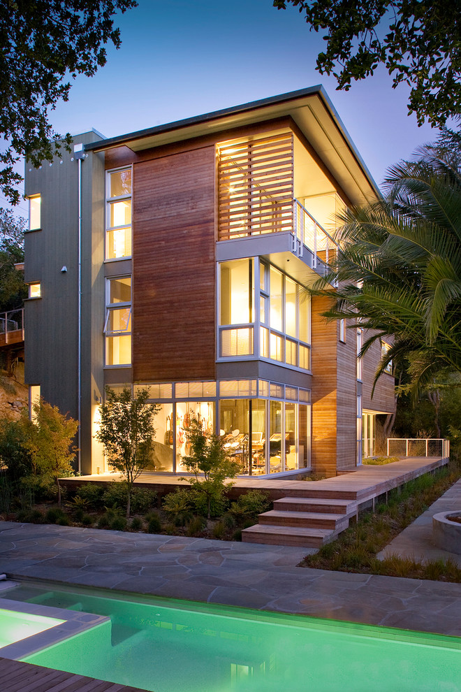 This is an example of a contemporary three-storey exterior in San Francisco with wood siding and a flat roof.