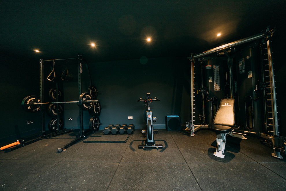 Photo of a mid-sized contemporary multipurpose gym in Surrey with black walls.
