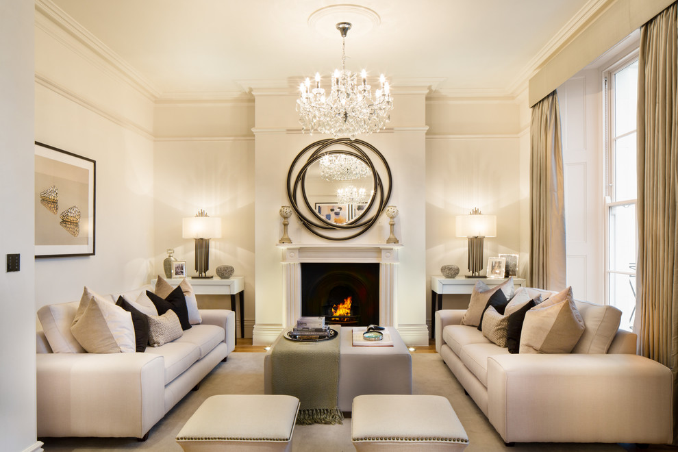 Inspiration for a transitional formal enclosed living room in London with beige walls, light hardwood floors and a standard fireplace.
