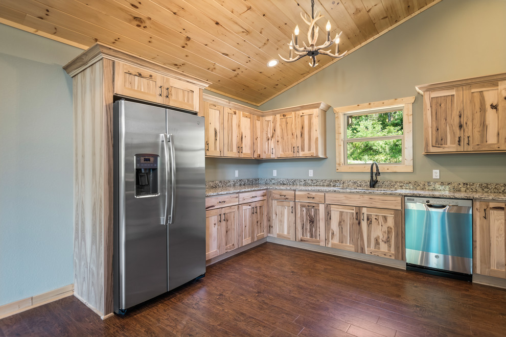 Large mountain style u-shaped laminate floor and brown floor eat-in kitchen photo with a double-bowl sink, recessed-panel cabinets, light wood cabinets, granite countertops, multicolored backsplash, stainless steel appliances, no island and multicolored countertops