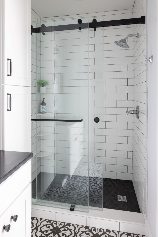 This is an example of a traditional shower room bathroom in Boston with shaker cabinets, white cabinets, an alcove shower, a bidet, white tiles, ceramic tiles, blue walls, porcelain flooring, a submerged sink, granite worktops, black floors, a sliding door, black worktops, a single sink and a built in vanity unit.