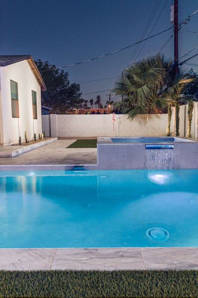 Photo of a mid-sized modern backyard rectangular pool in Phoenix with a hot tub and natural stone pavers.