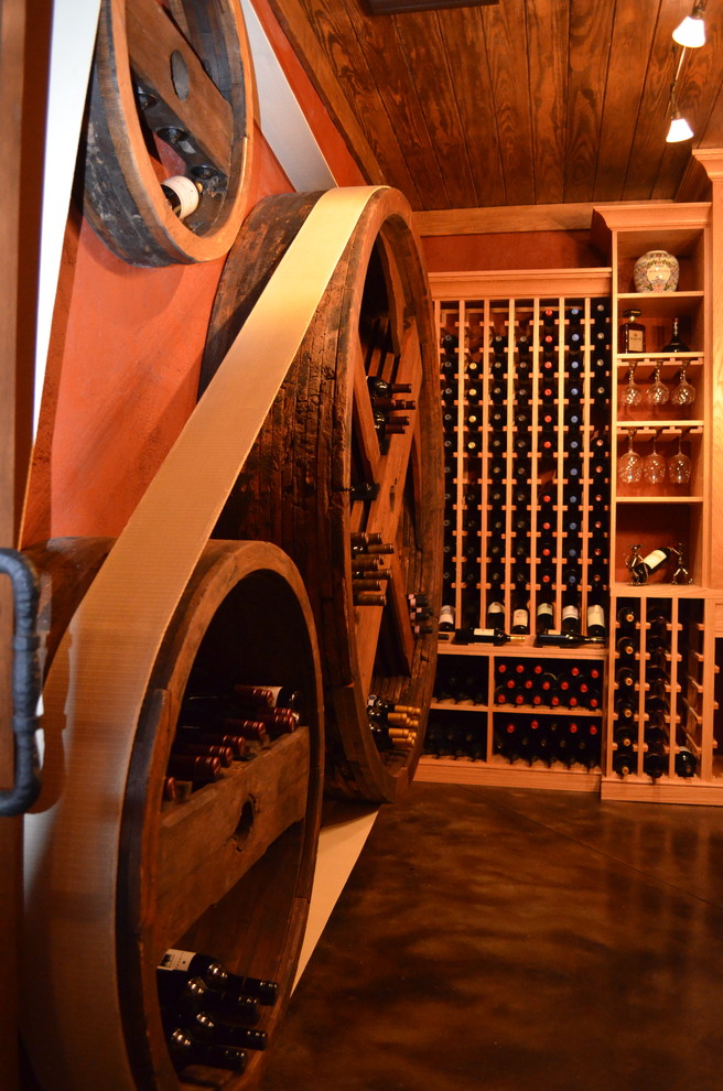 This is an example of a large eclectic wine cellar in Charlotte with concrete floors and storage racks.