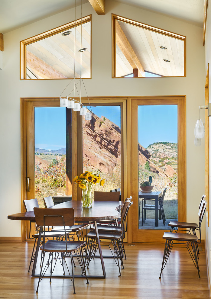 Large contemporary open plan dining in Denver with beige walls and light hardwood floors.