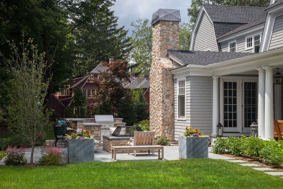 Mid-sized traditional backyard patio in Boston with an outdoor kitchen, natural stone pavers and no cover.