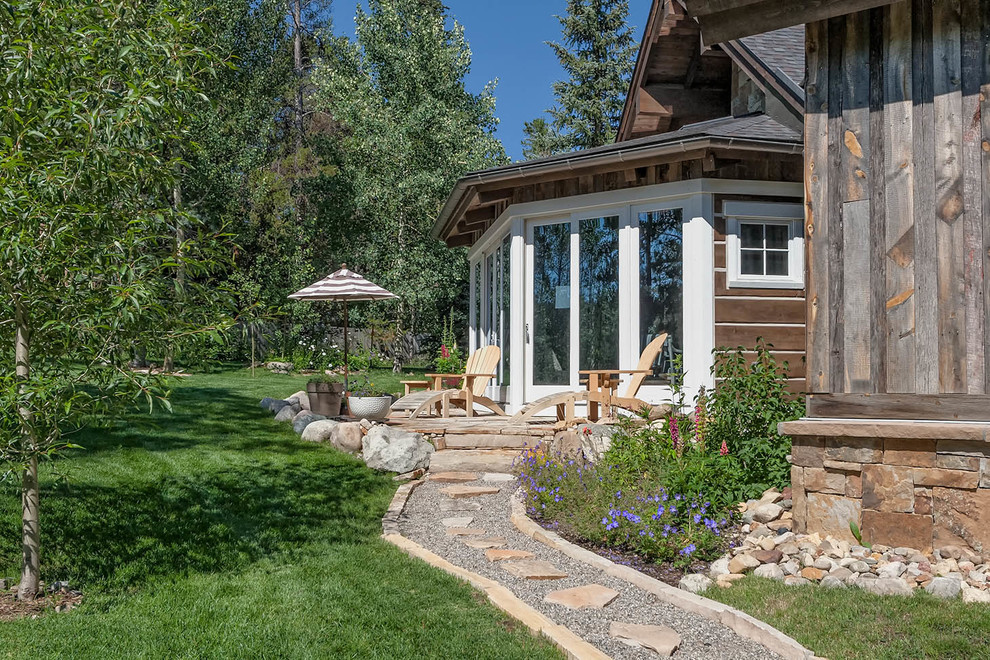 Photo of a country backyard garden in Denver with natural stone pavers.