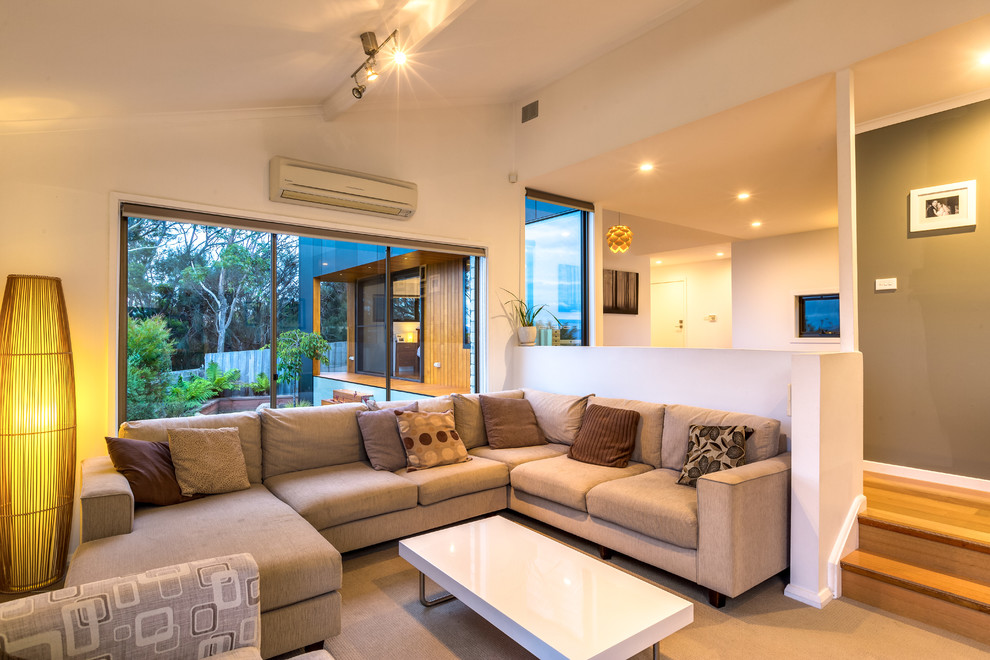 This is an example of a large contemporary formal open concept living room in Hobart with white walls and medium hardwood floors.