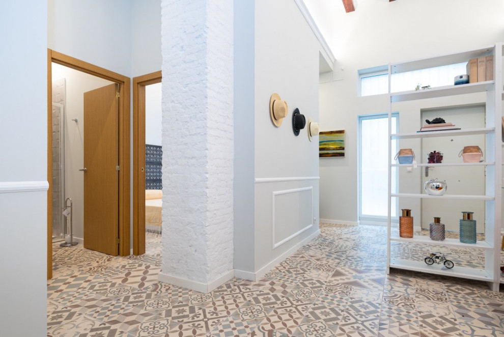 Immagine di un soggiorno chic di medie dimensioni e aperto con pareti bianche, pavimento con piastrelle in ceramica, TV a parete, pavimento multicolore e travi a vista