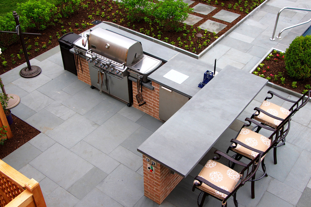 Design ideas for a mid-sized traditional backyard patio in Chicago with an outdoor kitchen, natural stone pavers and no cover.