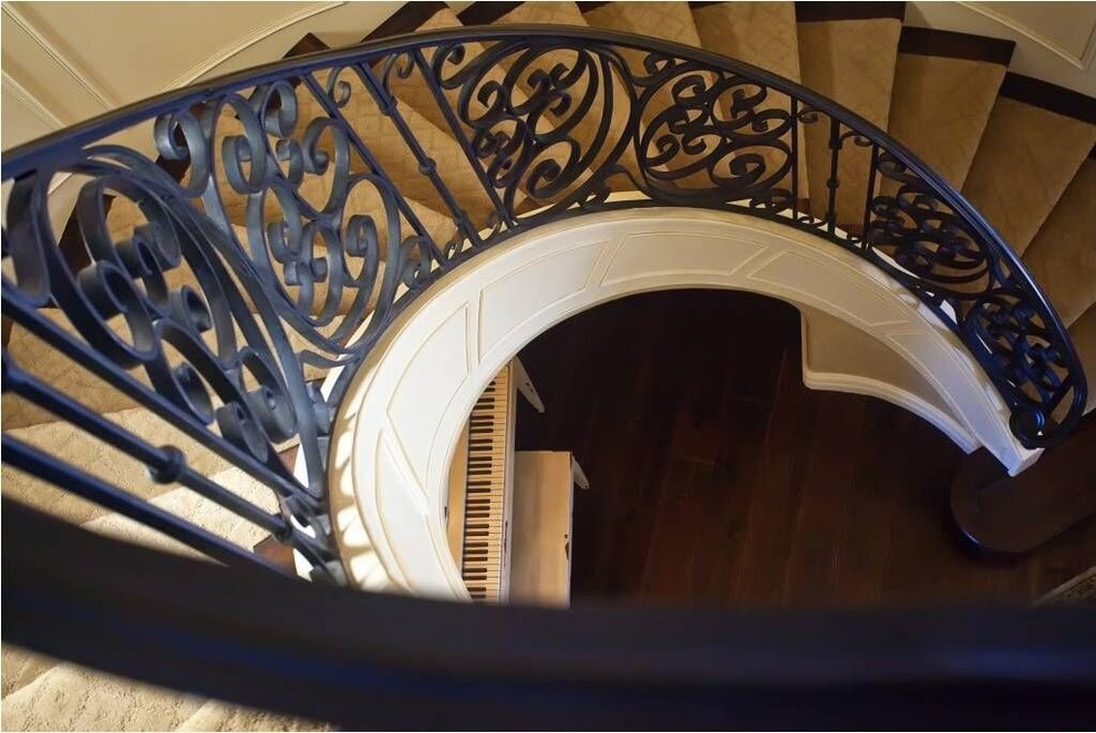 Staircase - mid-sized transitional wooden curved metal railing staircase idea in Phoenix