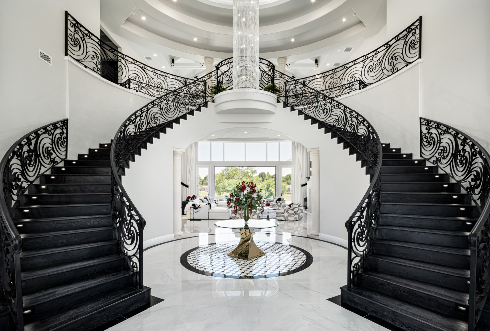 Idée de décoration pour un grand escalier minimaliste en U avec des marches en bois, un garde-corps en métal, des contremarches en marbre et du lambris.