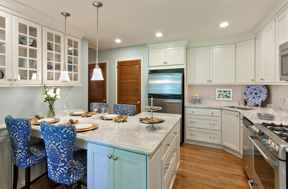 Example of a mid-sized transitional l-shaped light wood floor and brown floor eat-in kitchen design in Baltimore with an undermount sink, recessed-panel cabinets, white cabinets, marble countertops, mosaic tile backsplash, stainless steel appliances, a peninsula and white backsplash
