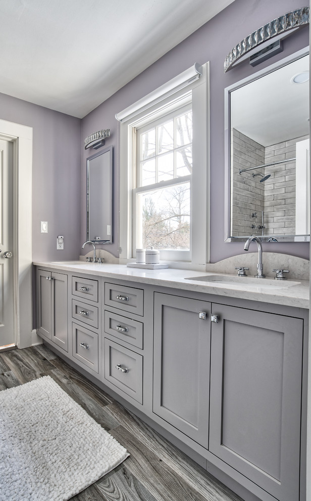 Design ideas for a mid-sized traditional kids bathroom in New York with beaded inset cabinets, a drop-in tub, a shower/bathtub combo, a one-piece toilet, gray tile, ceramic tile, purple walls, an undermount sink, grey floor and a shower curtain.