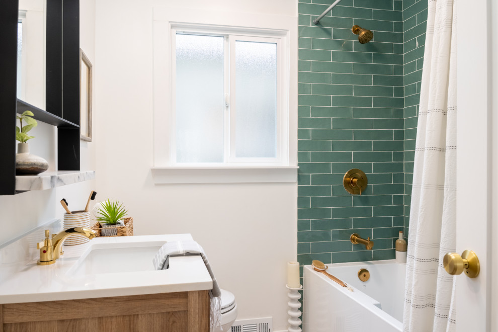 На фото: маленькая ванная комната в стиле фьюжн с фасадами в стиле шейкер, фасадами цвета дерева среднего тона, ванной в нише, душем над ванной, раздельным унитазом, зеленой плиткой, керамогранитной плиткой, белыми стенами, полом из керамогранита, душевой кабиной, врезной раковиной, столешницей из искусственного камня, серым полом, шторкой для ванной, белой столешницей и тумбой под одну раковину для на участке и в саду