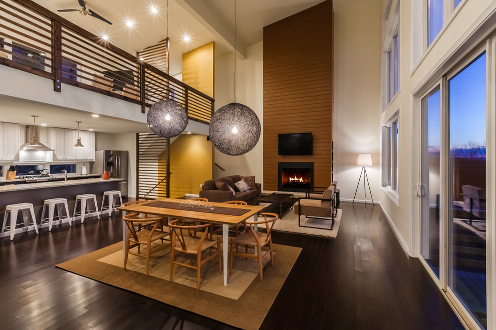 This is an example of a large contemporary open plan dining in New York with dark hardwood floors, a standard fireplace, a metal fireplace surround, brown floor and white walls.