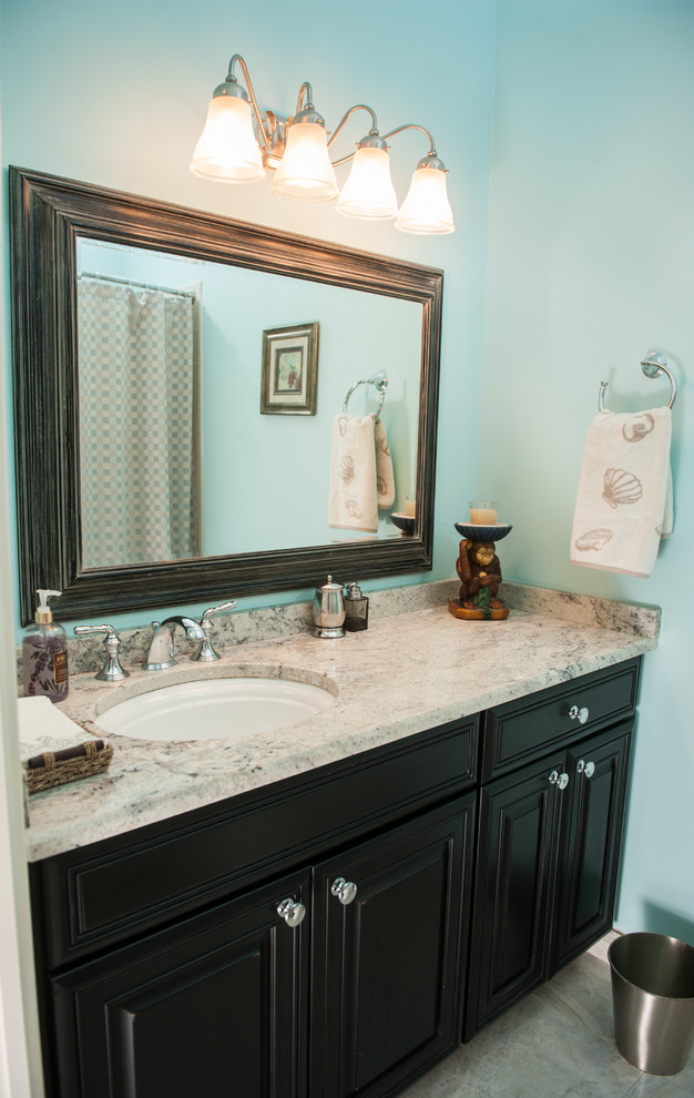 Inspiration for a mid-sized transitional master marble floor bathroom remodel in Miami with raised-panel cabinets, black cabinets, a two-piece toilet, blue walls, an undermount sink and granite countertops