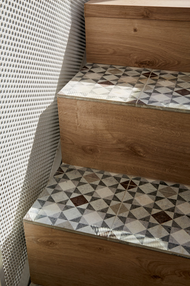 Diseño de escalera recta mediterránea con escalones con baldosas, contrahuellas de madera, barandilla de metal y ladrillo