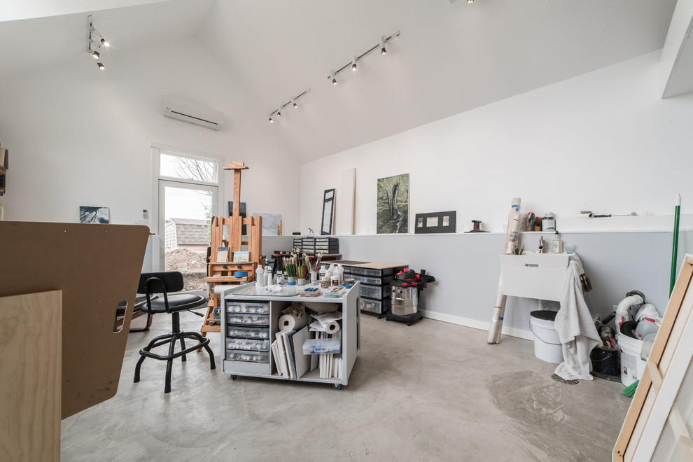 Large contemporary home studio in Chicago with concrete floors, a freestanding desk, grey floor and grey walls.
