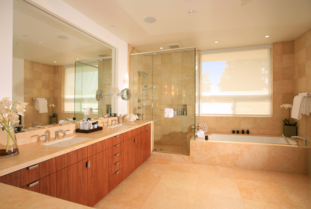 Modern master bathroom in Los Angeles with an undermount sink, flat-panel cabinets, medium wood cabinets, marble benchtops, an undermount tub, a corner shower, white walls and marble floors.