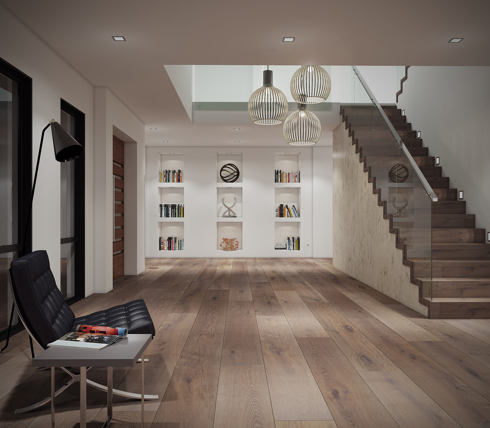 This is an example of a large modern foyer in Melbourne with white walls, light hardwood floors, a pivot front door and a medium wood front door.