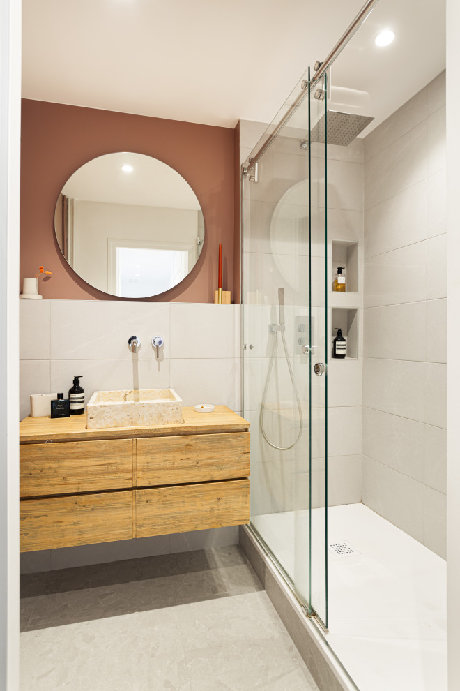 Foto på ett litet funkis en-suite badrum, med skåp i ljust trä, en öppen dusch, en toalettstol med separat cisternkåpa, grå kakel, stenhäll, rosa väggar, ett fristående handfat, träbänkskiva, grått golv och dusch med skjutdörr