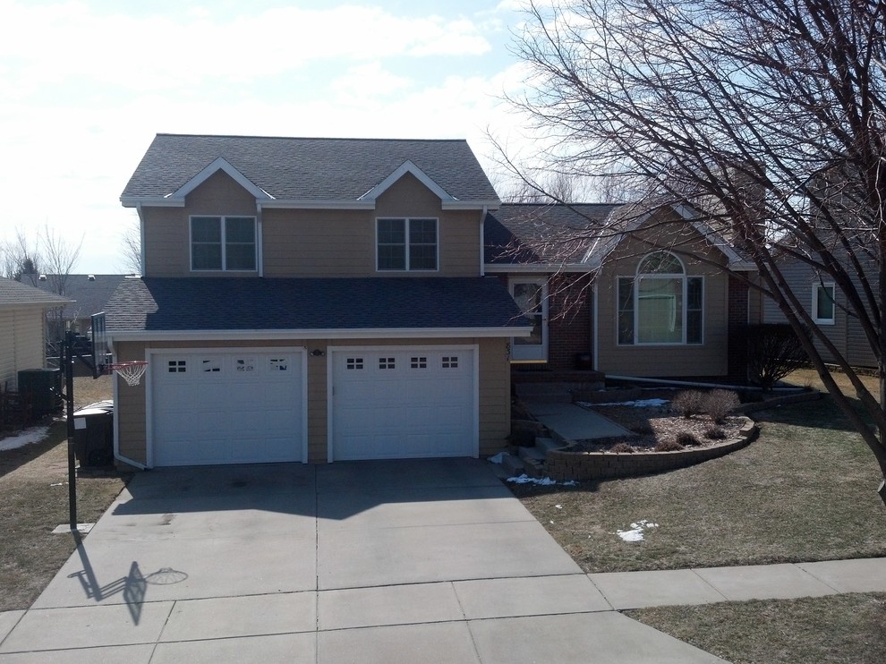 Photo of a mid-sized traditional split-level beige exterior in Omaha with a gable roof.