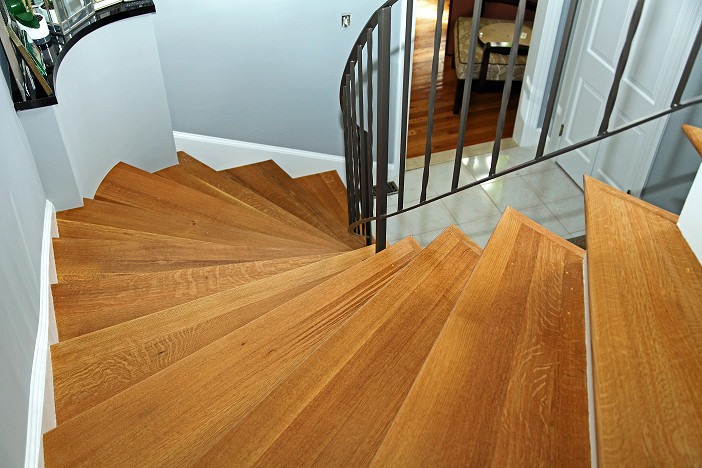 Photo of a mid-sized traditional wood curved staircase in Boston with wood risers and metal railing.