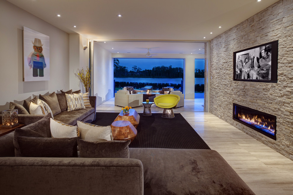 This is an example of a contemporary living room in Houston with white walls, a ribbon fireplace, a stone fireplace surround and a wall-mounted tv.