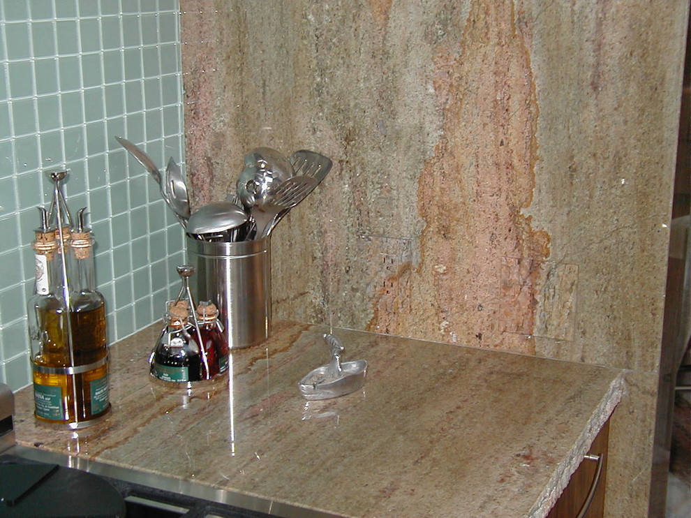 Example of a minimalist kitchen design with granite countertops and blue backsplash
