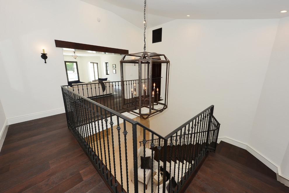 Photo of an expansive mediterranean wood u-shaped staircase in Los Angeles with wood risers and metal railing.