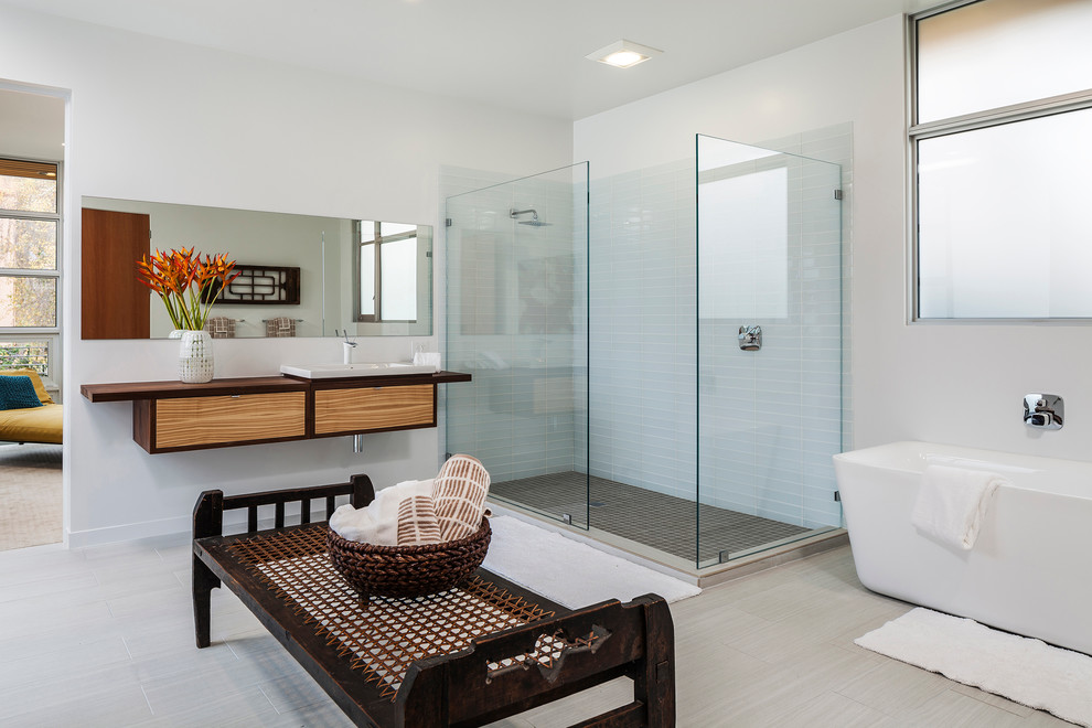 Photo of a contemporary master bathroom in San Francisco with a drop-in sink, flat-panel cabinets, a freestanding tub, white tile, glass tile, white walls, an open shower, ceramic floors, medium wood cabinets and an open shower.