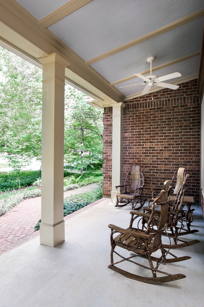 Inspiration for a mid-sized traditional front yard verandah in Atlanta with brick pavers and a roof extension.