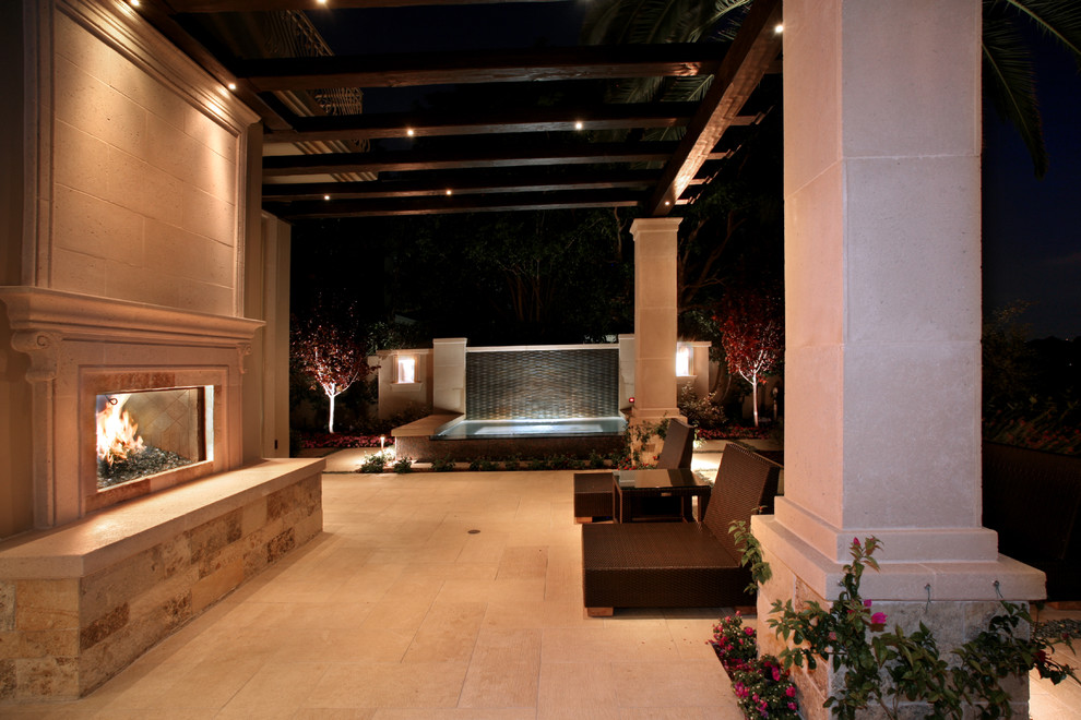 This is an example of a mediterranean patio in Los Angeles with a fire feature and a pergola.