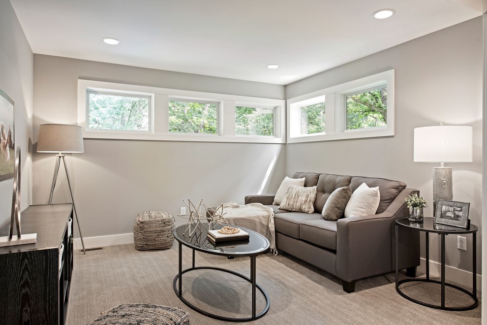 This is an example of a mid-sized transitional open concept family room in Minneapolis with grey walls, carpet, no fireplace, a wall-mounted tv and grey floor.