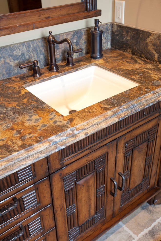 Photo of a country master bathroom in Salt Lake City with brown cabinets, porcelain floors, granite benchtops, beige floor, beige benchtops, a single vanity and a built-in vanity.