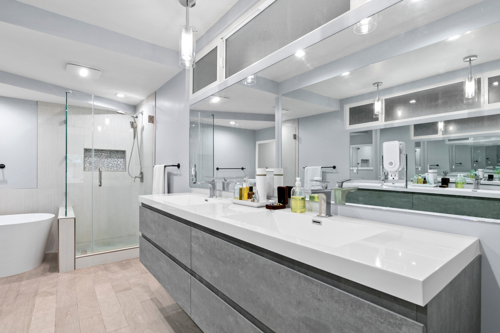 Idéer för ett stort modernt vit en-suite badrum, med släta luckor, grå skåp, ett fristående badkar, en dusch i en alkov, en toalettstol med hel cisternkåpa, grå kakel, stenkakel, grå väggar, ljust trägolv, ett nedsänkt handfat, marmorbänkskiva, beiget golv och dusch med gångjärnsdörr