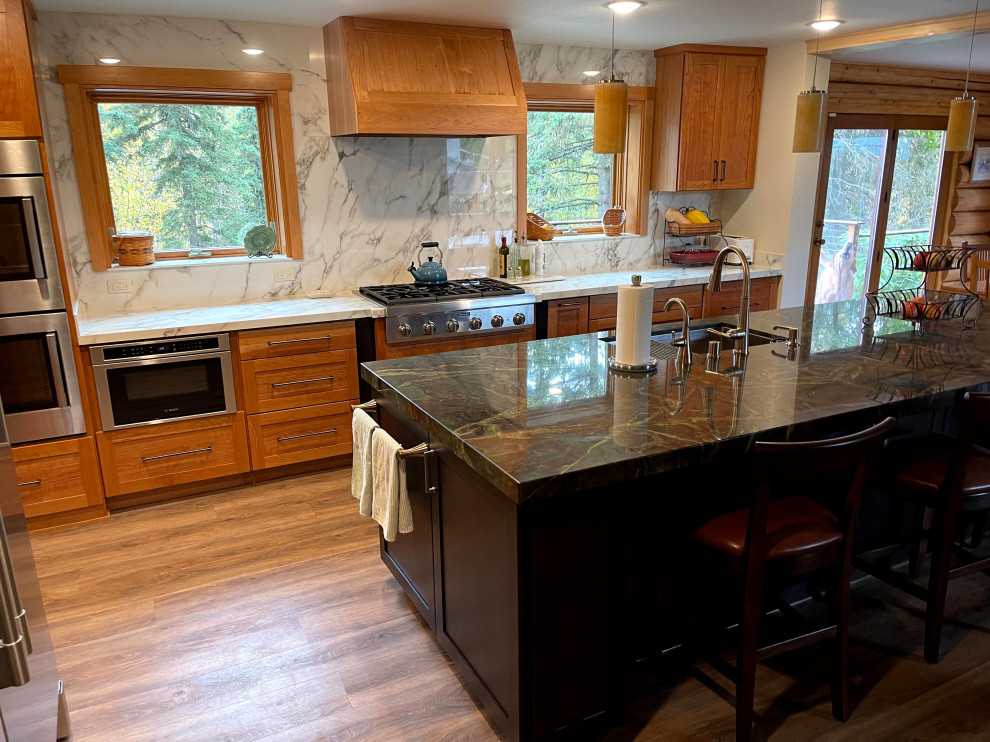 Inspiration for a large country l-shaped eat-in kitchen in Other with an undermount sink, shaker cabinets, light wood cabinets, quartzite benchtops, white splashback, porcelain splashback, stainless steel appliances, vinyl floors, with island, brown floor and green benchtop.