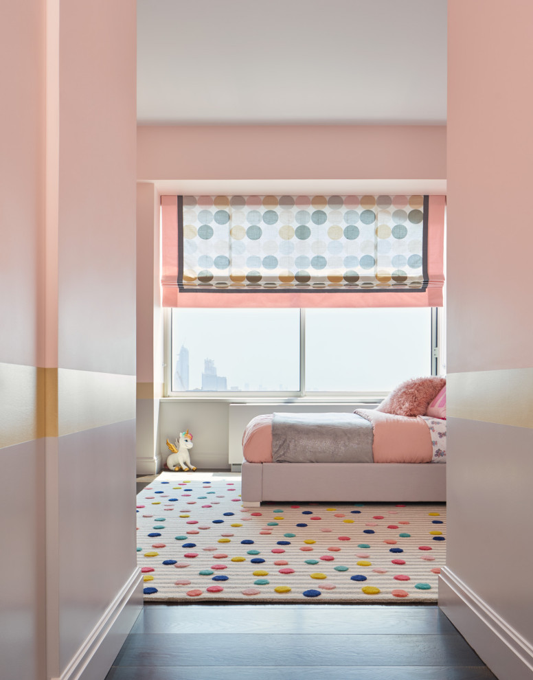 Cette image montre une chambre d'enfant de 4 à 10 ans design de taille moyenne avec un mur rose, parquet foncé et un sol marron.