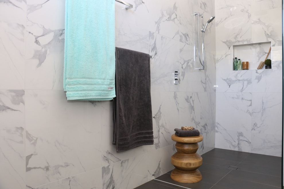 Mid-sized modern master bathroom in Sydney with white cabinets, an open shower, a wall-mount toilet, white tile, porcelain tile, white walls, porcelain floors, a vessel sink and engineered quartz benchtops.