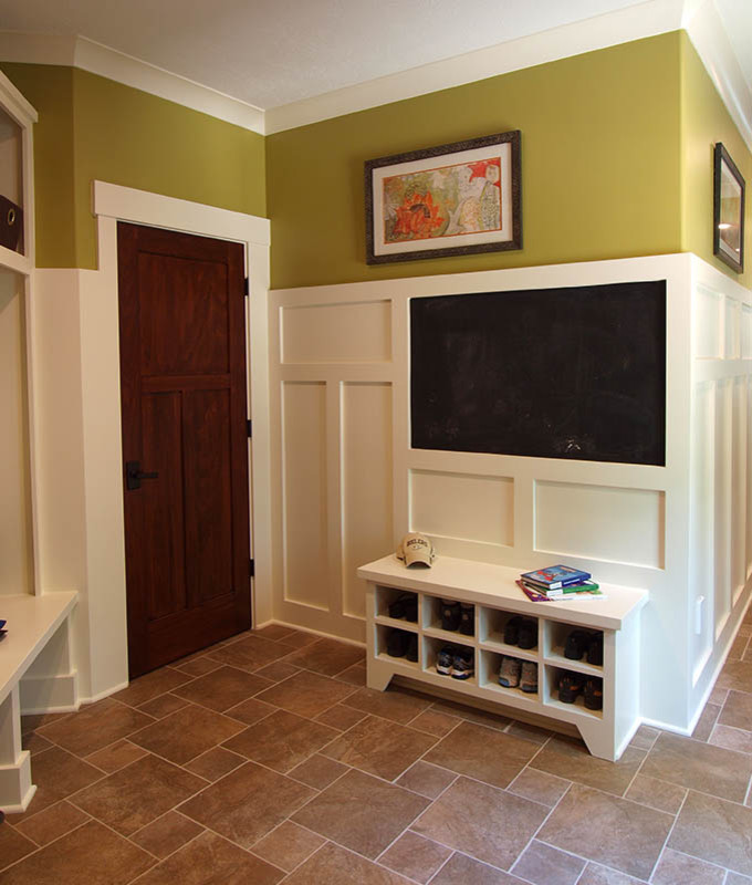 Inspiration for a mid-sized arts and crafts mudroom in Indianapolis with brown walls, travertine floors, a single front door, a dark wood front door and brown floor.